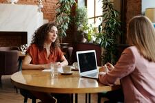 Two women talking over a table