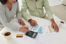 Older Couple Using Calculator and Viewing Financial Documents