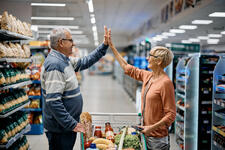 Senior Couple High Five for Successful Shopping at Supermarket