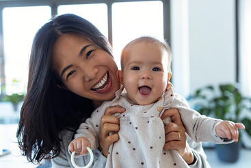 Woman holding her smiling baby